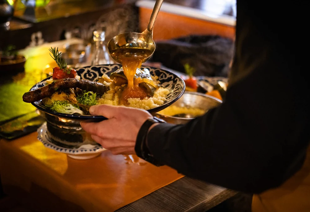 Convives partageant un repas autour de plats et de boissons.
