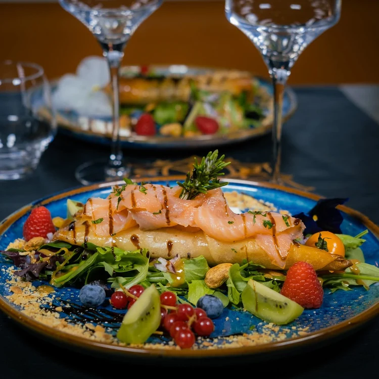 Assiette de poisson accompagnée de légumes et de salade.